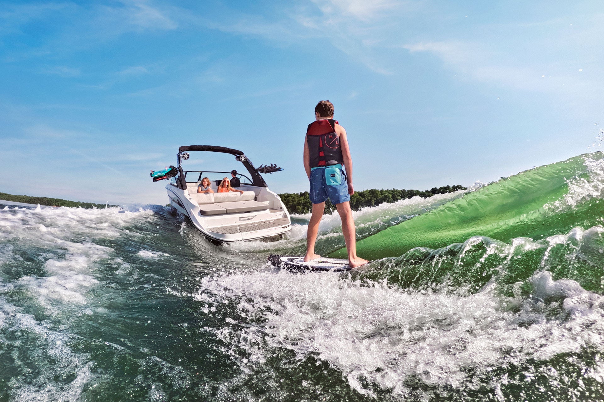 Kid wakesurfing behind an SDX 230 Surf