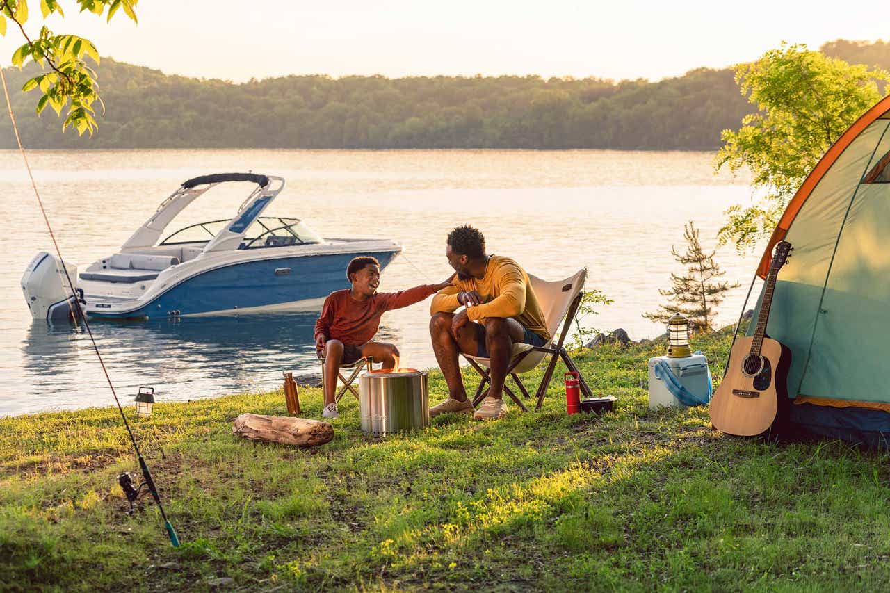 Family at a campsite next to an SDX 230 Outboard
