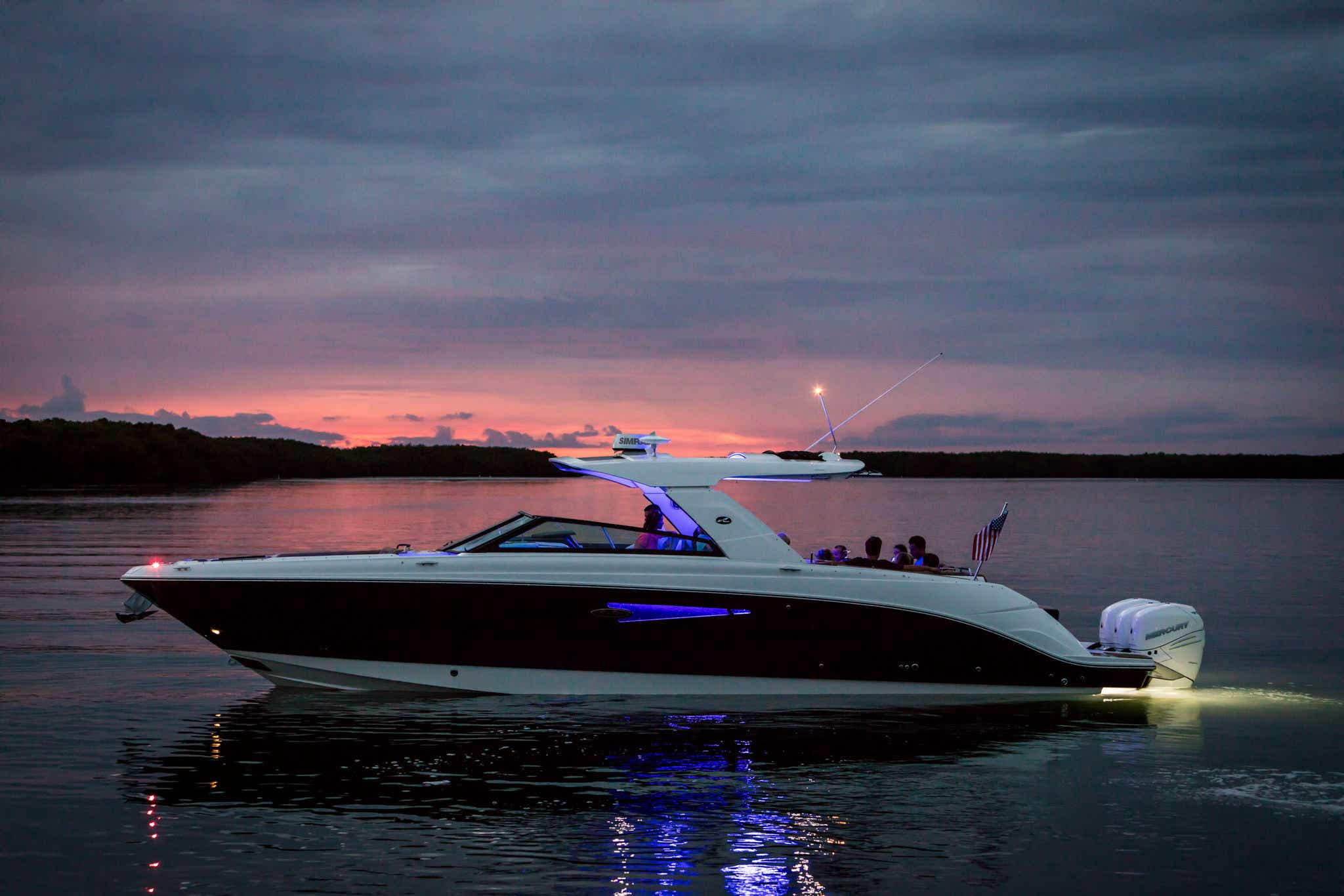 2024 SLX 400 Outboard port profile view of friends with accent lighting at twilight