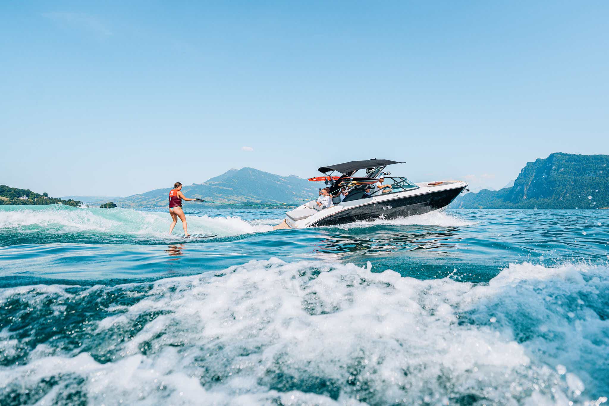 Sea Ray boat running starboard with surfer behind
