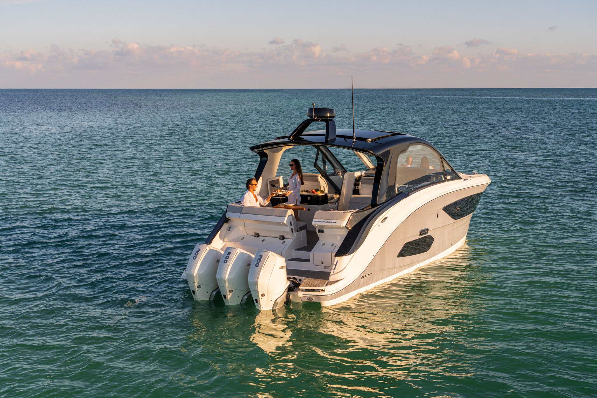Couple using wet bar and grill on 2024 Sundancer 370 Outboard