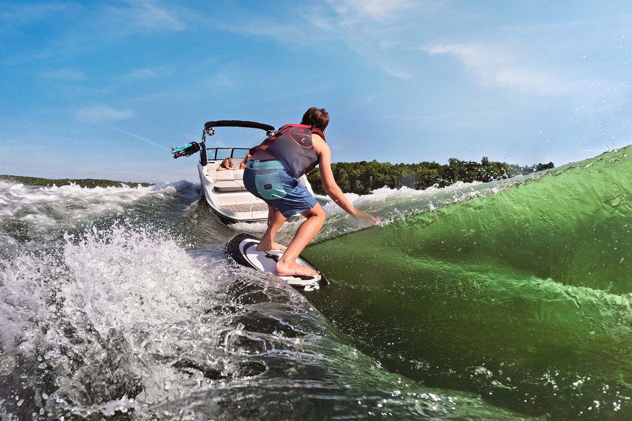 Kid wakesurfing behind an SDX 230 Surf