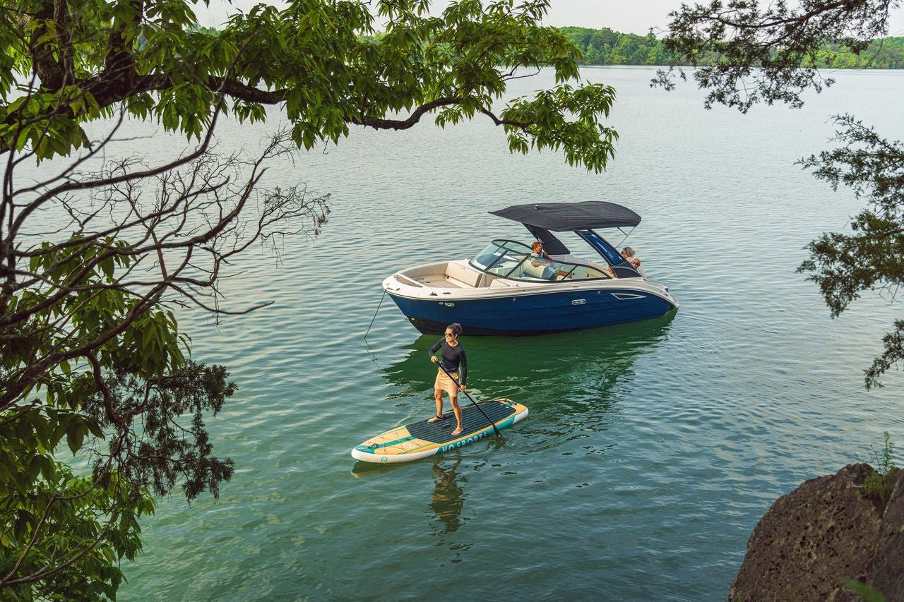 Woman paddleboarding next to an SDX 230