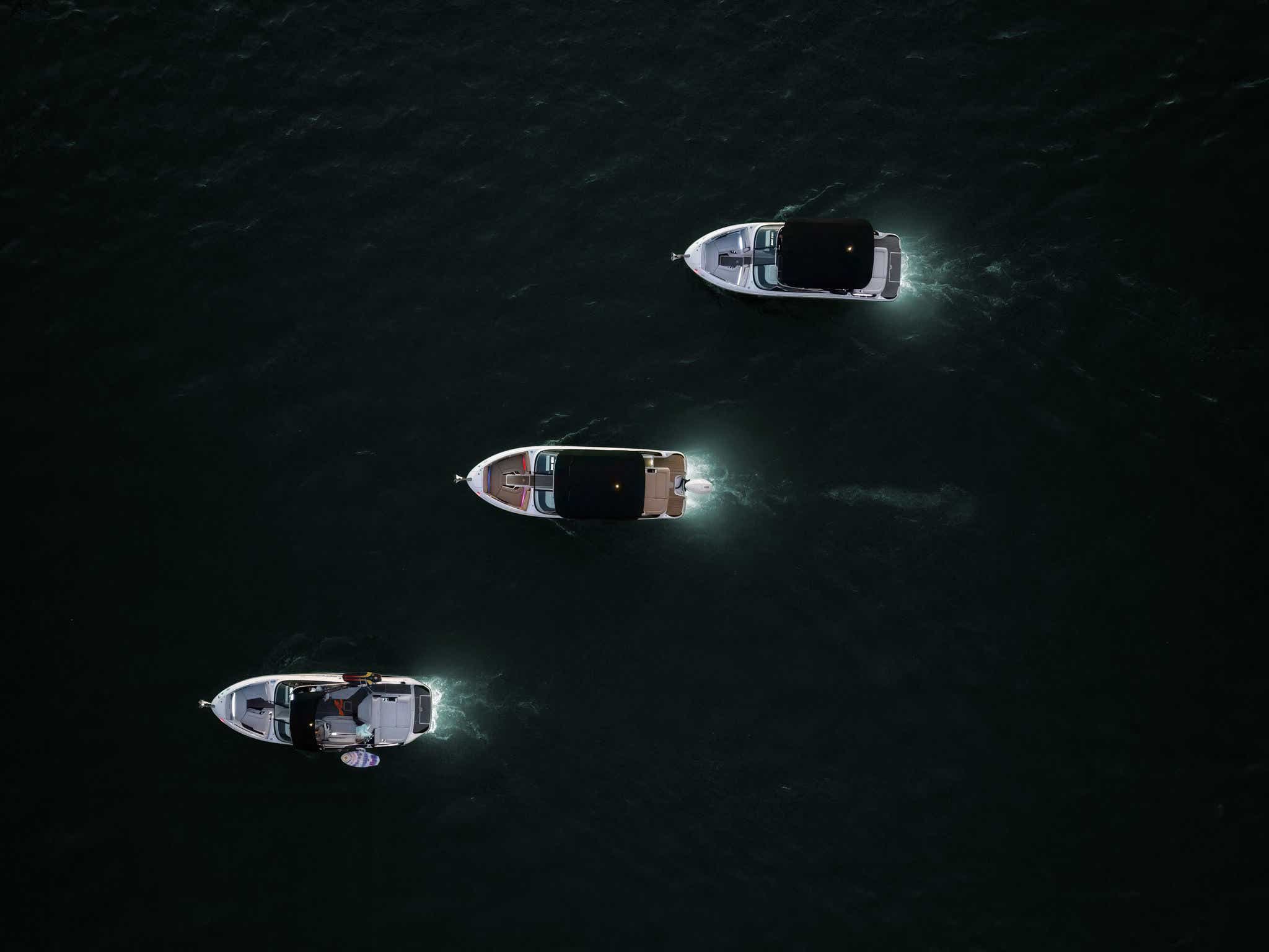 Aerial view of an SLX 260, SLX 260 Outboard and SLX 260 Surf at twilight