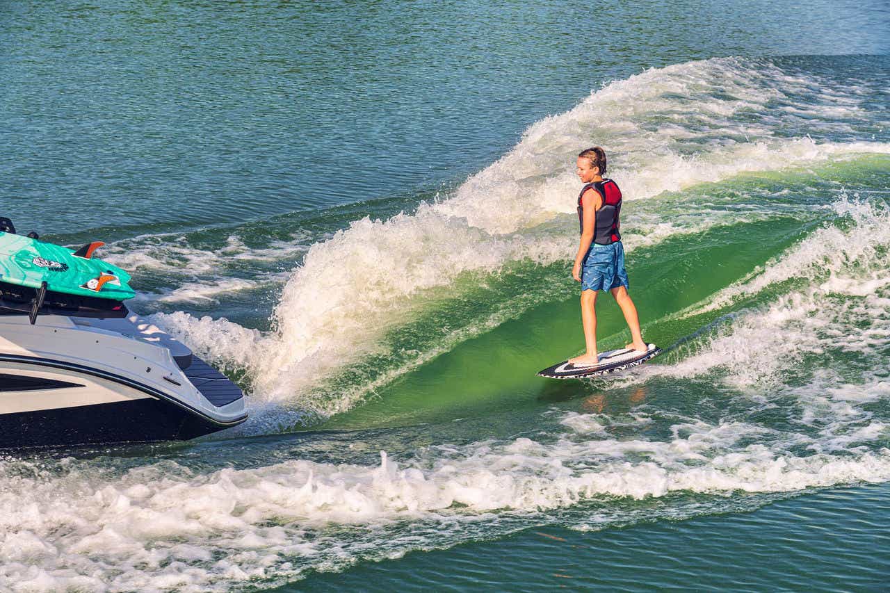 Kid wakesurfing behind an SDX 230 Surf