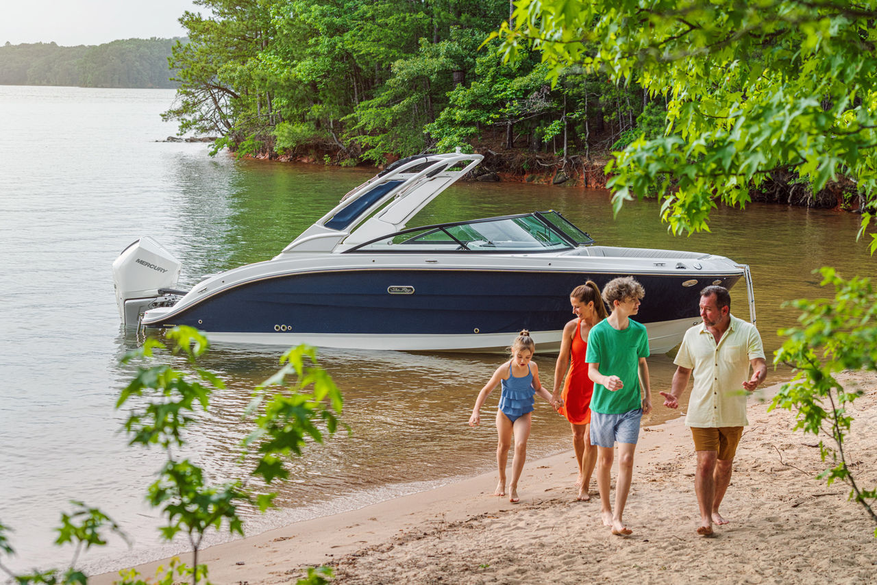 Family walking on a beach next to an SDX 250 Outboard