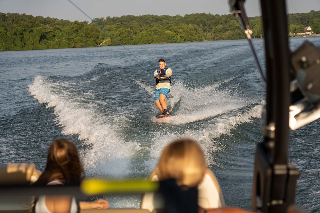 Young man wakeboarding behind an SDX 290