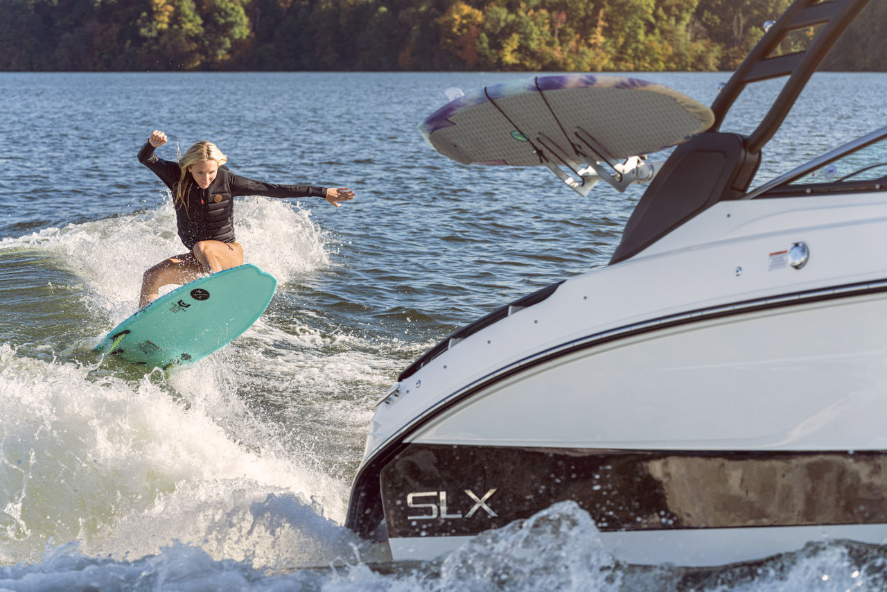 Woman wakesurfing behind an SLX 260 Surf