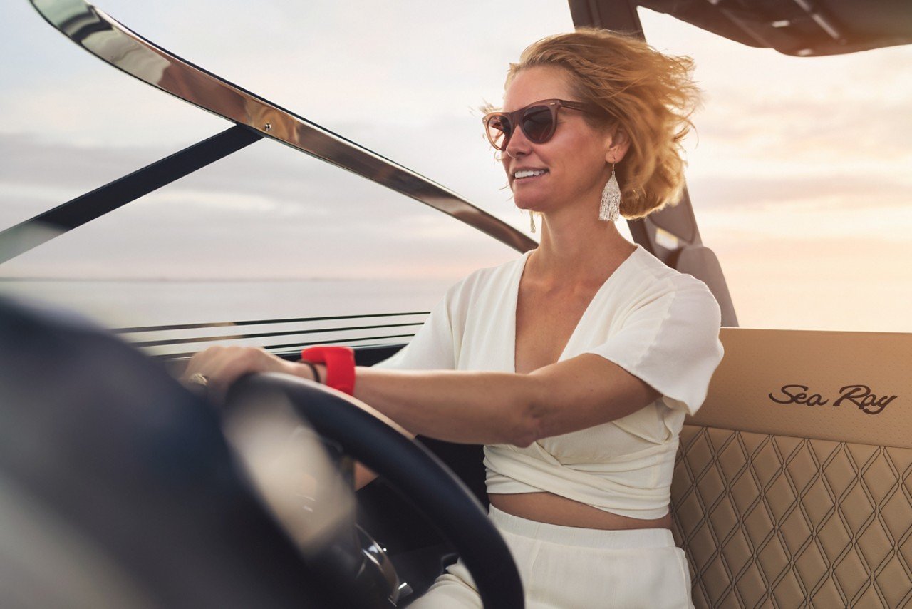 Woman with sunglasses at the helm of an SLX 280 Outboard