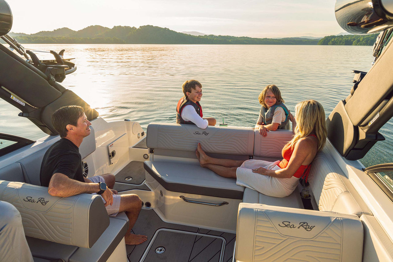 Family aboard an SDX 230 Surf at sunset