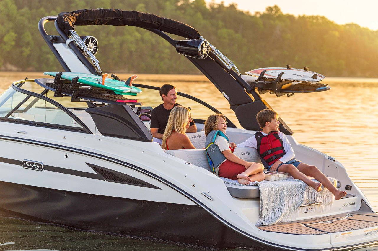 Family aboard an SDX 230 Surf at sunset