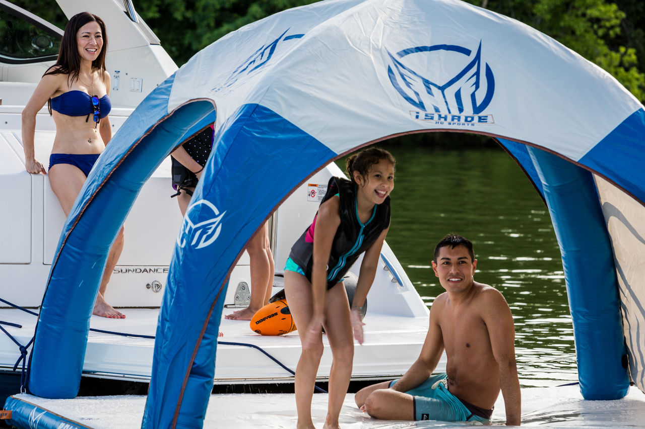 2024 Sundancer 320 and family in life jackets using swim platform