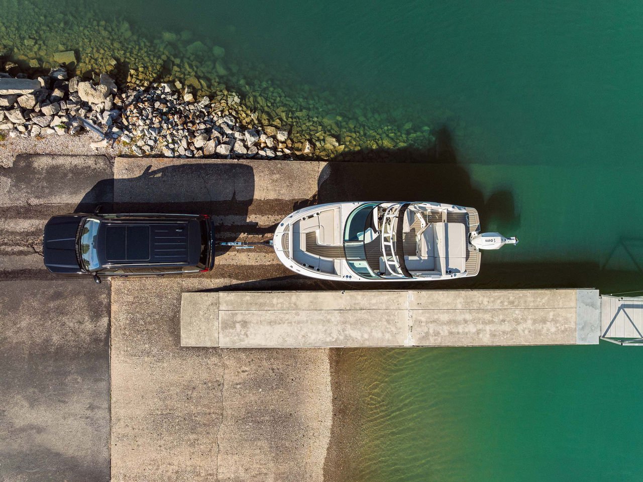 Aerial view of a SUV launching an SDX 230 Outboard at a boat ramp