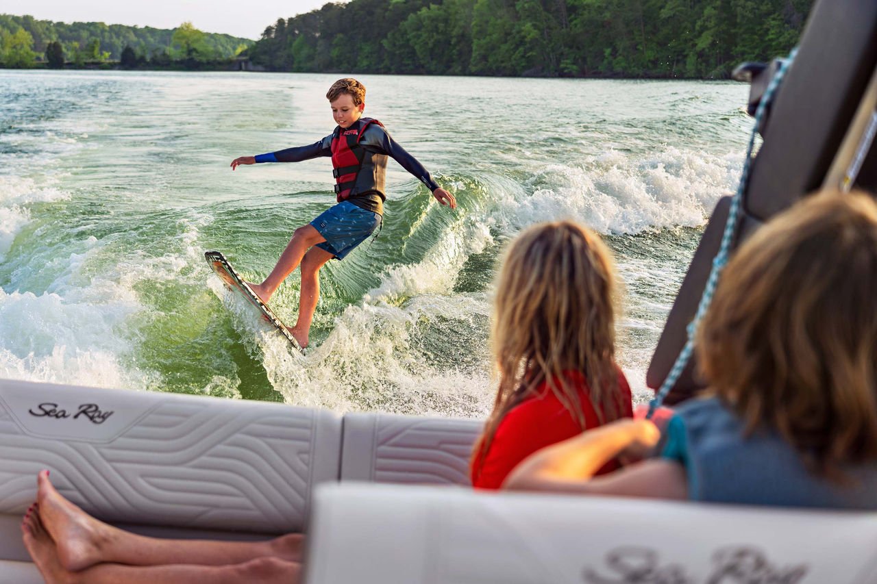 Kid wakesurfing behind an SDX 230 Surf