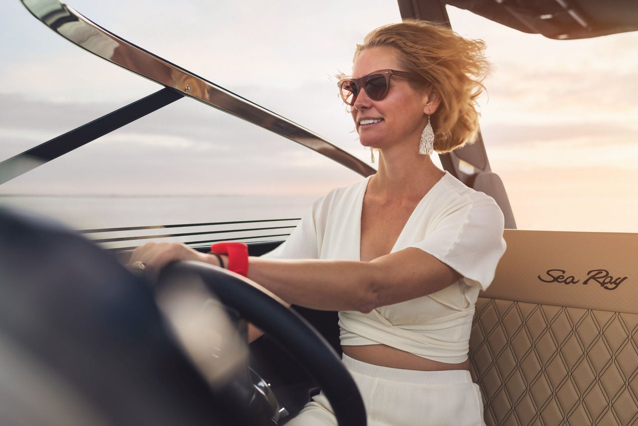 Woman with sunglasses at the helm of an SLX 280 Outboard